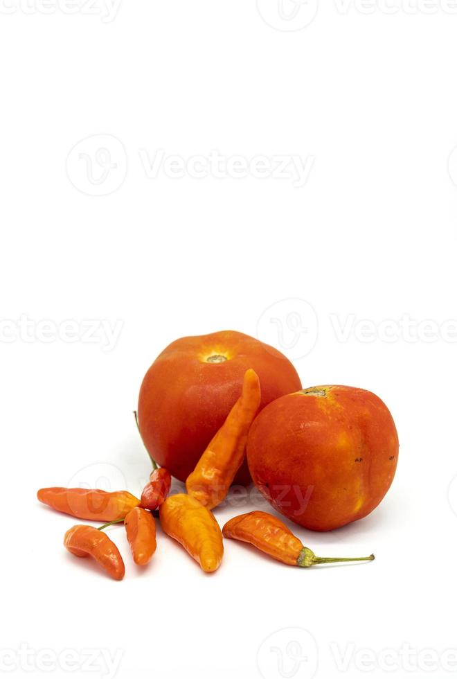 Tomates orange et piments sur fond blanc photo