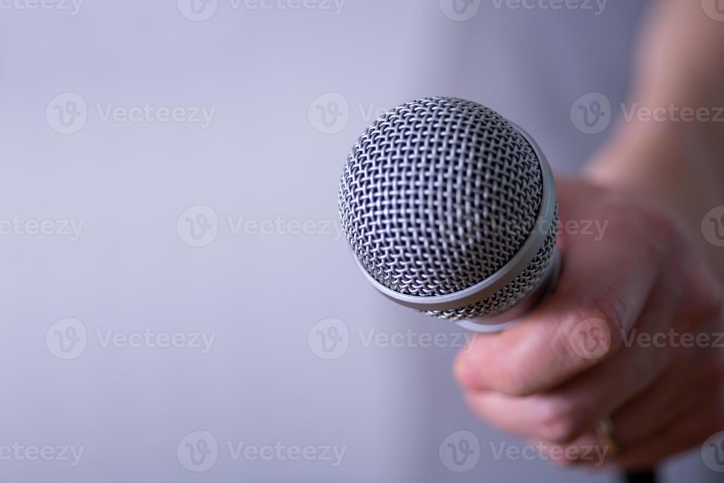 un homme tient un microphone dans sa main avec de la place pour copier. photo