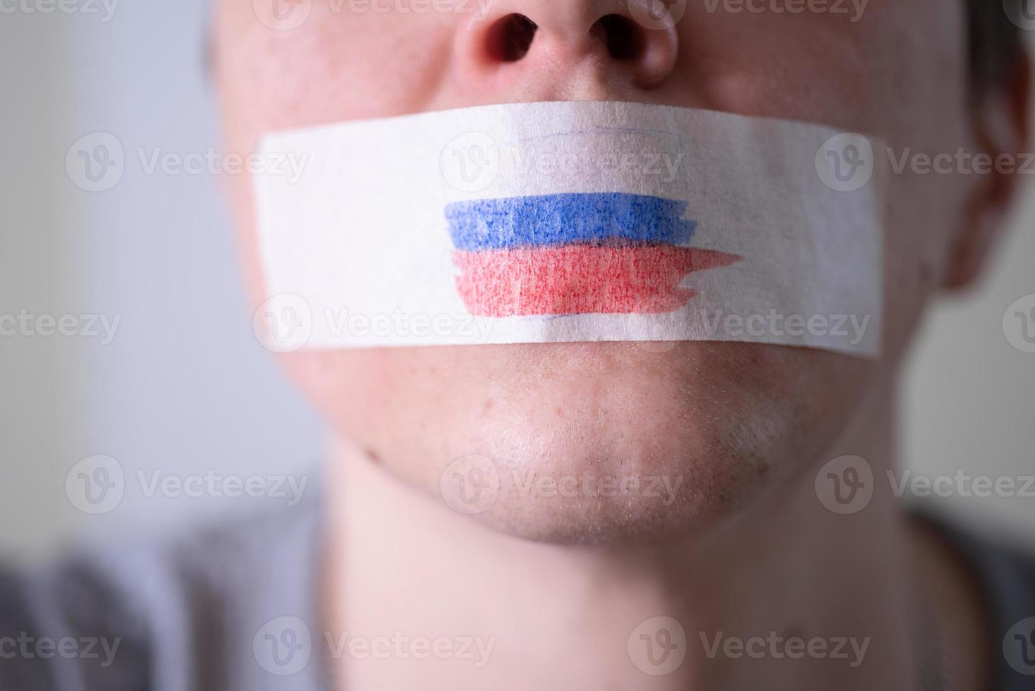 une bouche scotchée avec un drapeau russe, essayant de dire. photo