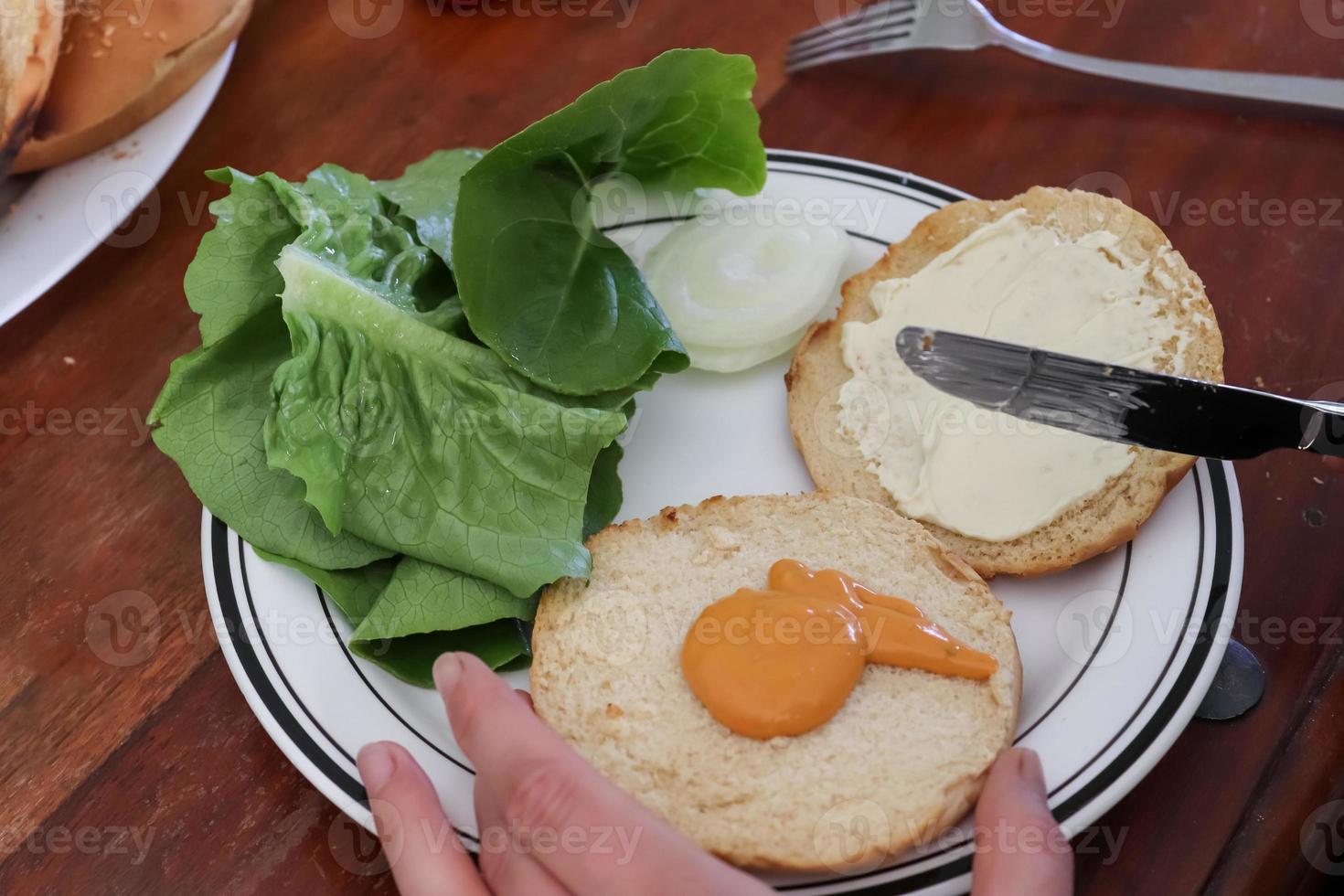 fabrication maison d'un hamburger grillé avec tomates et salade sur une assiette photo