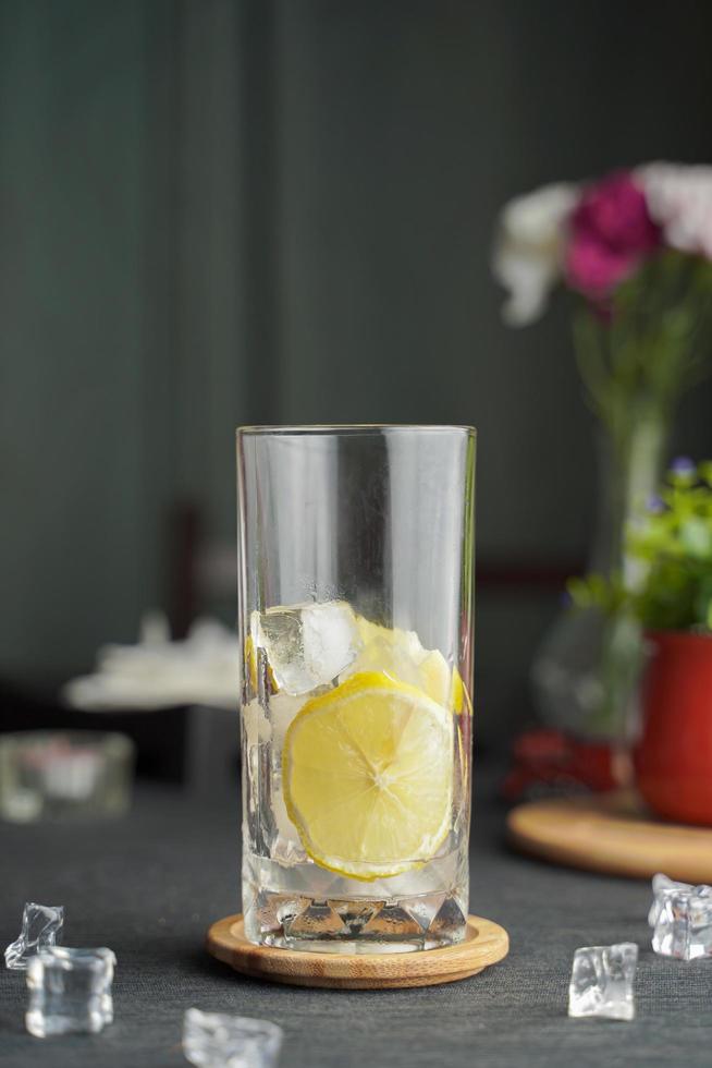 verre d'espresso avec jus de citron et citron frais tranché sur table en bois et espace de copie, cocktail d'été, café froid ou thé noir. photo