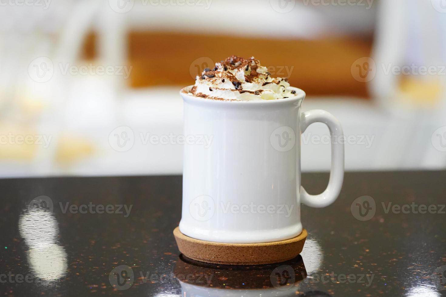 tasse à café blanche et crème fouettée sur le dessus. photo
