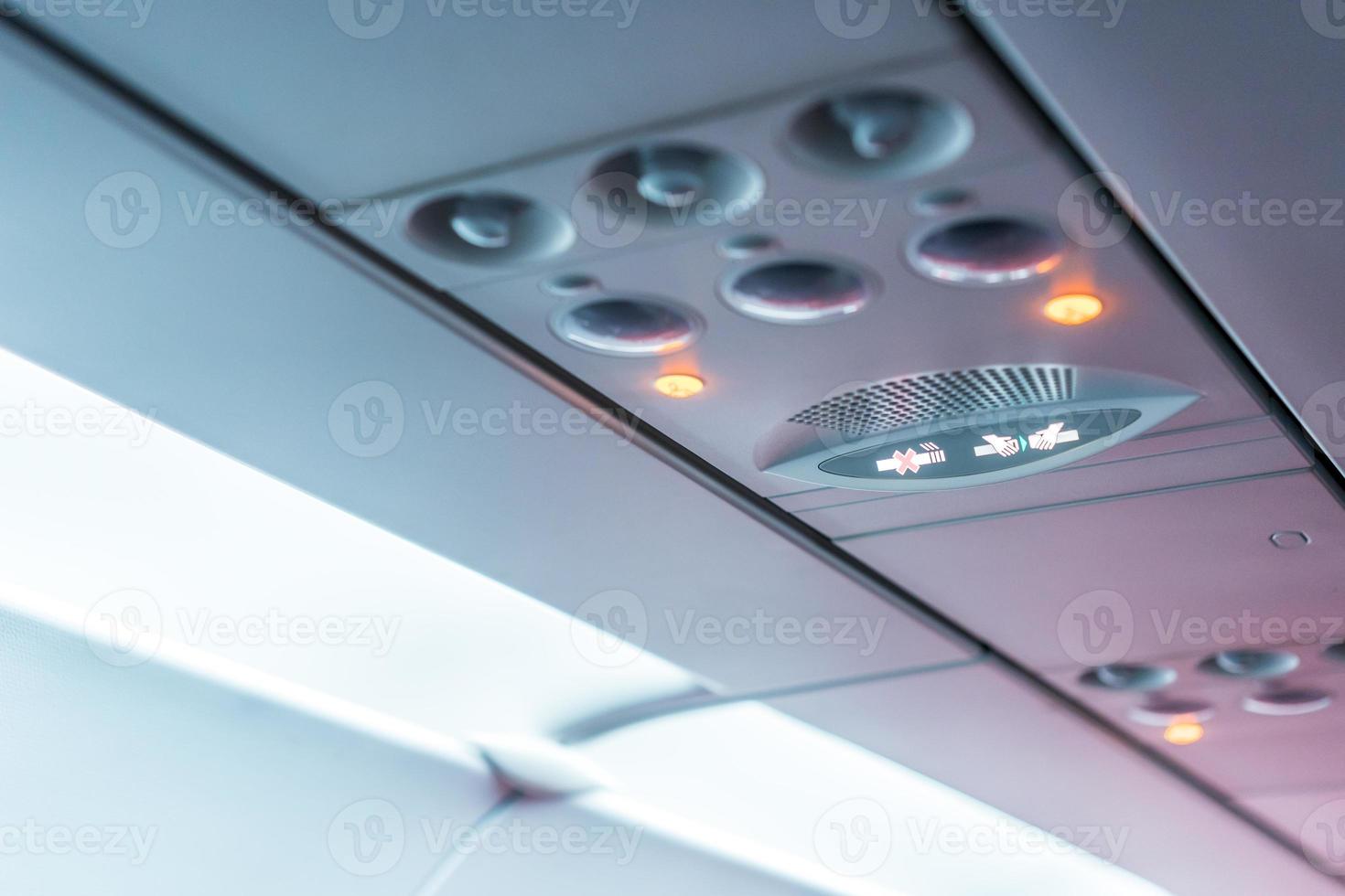 gros plan de la lampe du panneau de la console de l'avion, de la lumière, du bouton d'aide nécessaire, de la climatisation, de la ceinture de sécurité et du panneau d'éclairage non fumeur. photo