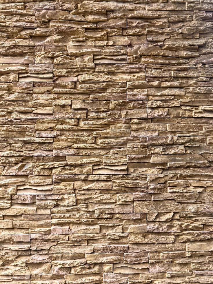 brique marron clair aléatoire classique disposée sur le mur pour décorer l'extérieur du bâtiment. photo