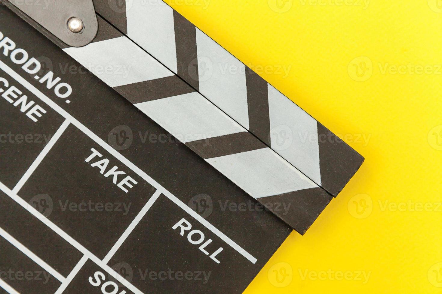 métier de cinéaste. réalisateur classique réalisation de films vides clap ou ardoise de film isolé sur fond jaune. concept de l'industrie du cinéma de production vidéo. maquette de l'espace de copie de la vue de dessus à plat. photo