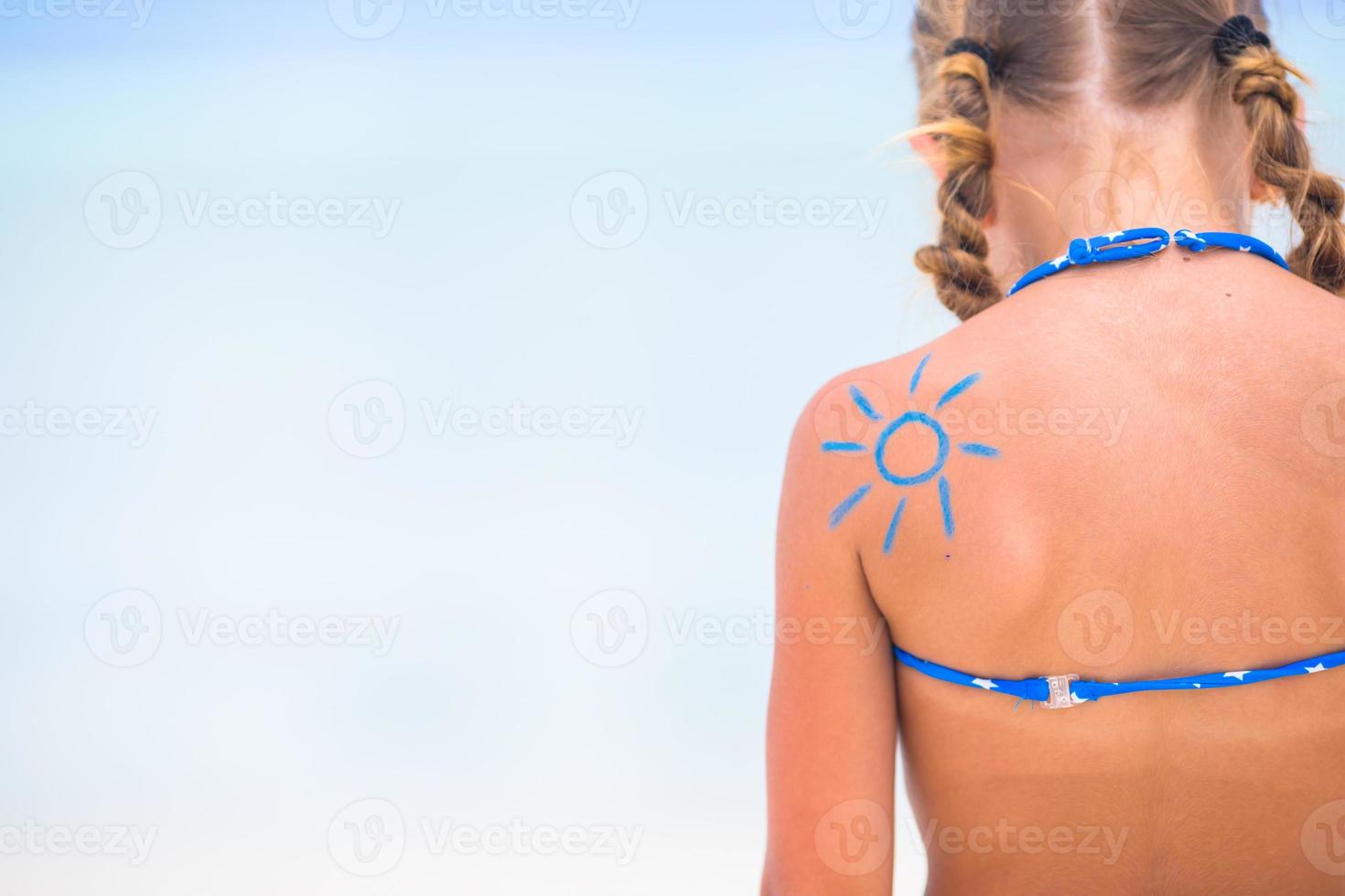 Close up sun peint par crème solaire sur l'épaule de l'enfant photo