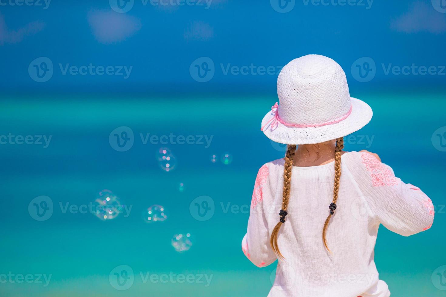 adorable petite fille faisant des bulles de savon pendant les vacances d'été photo