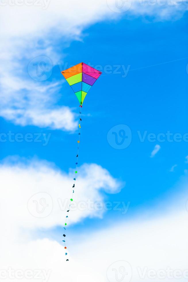 cerf-volant coloré volant dans le ciel bleu de fond de vent photo