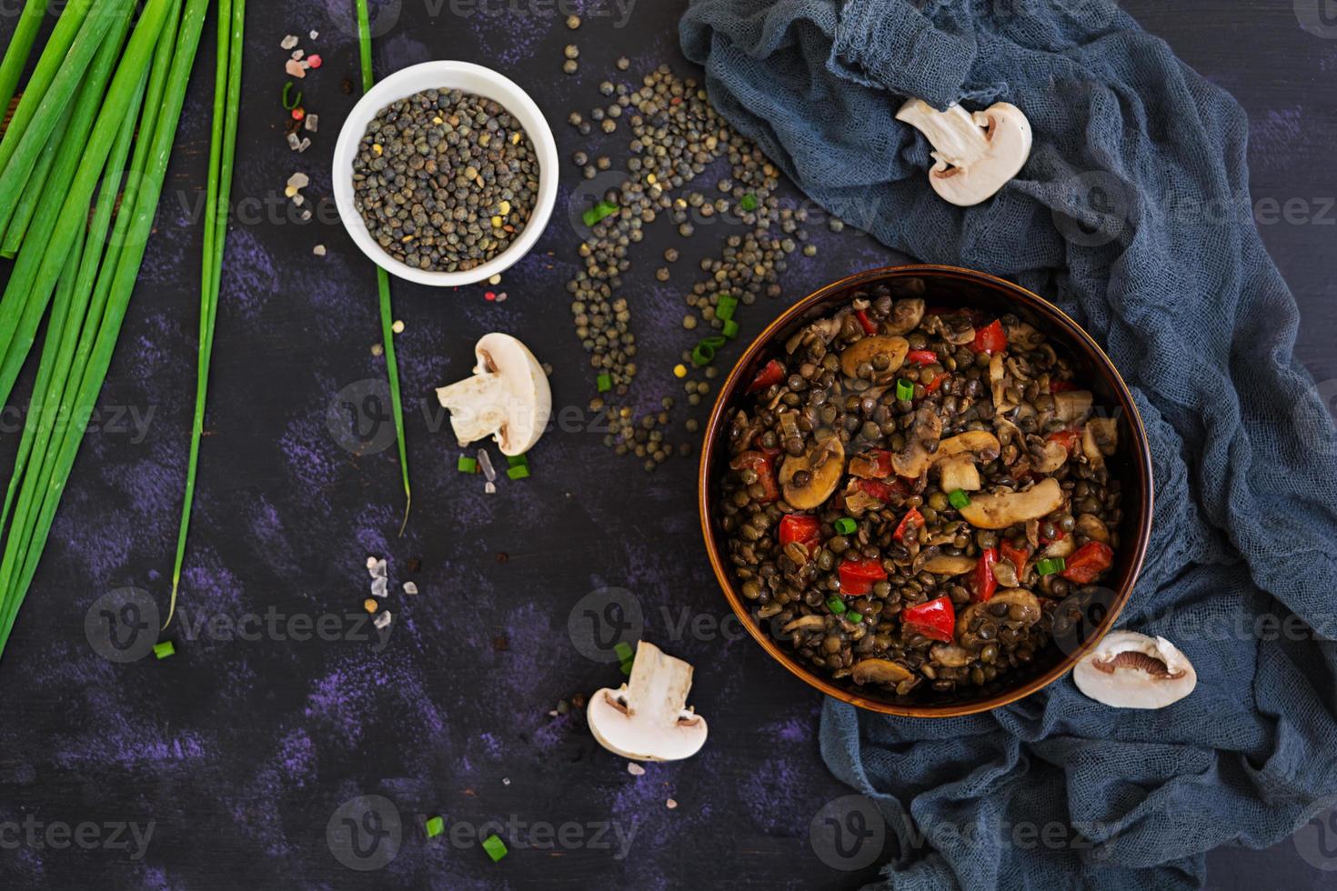 délicieuses lentilles au poivre et champignons sur fond sombre photo