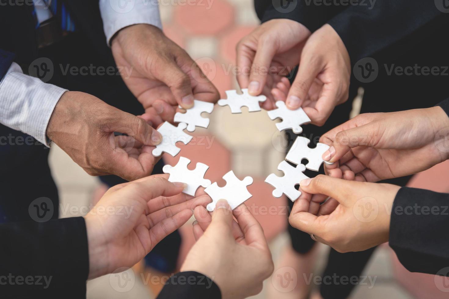 nous sommes compatibles un groupe d'hommes d'affaires travaille ensemble sur des puzzles. photo