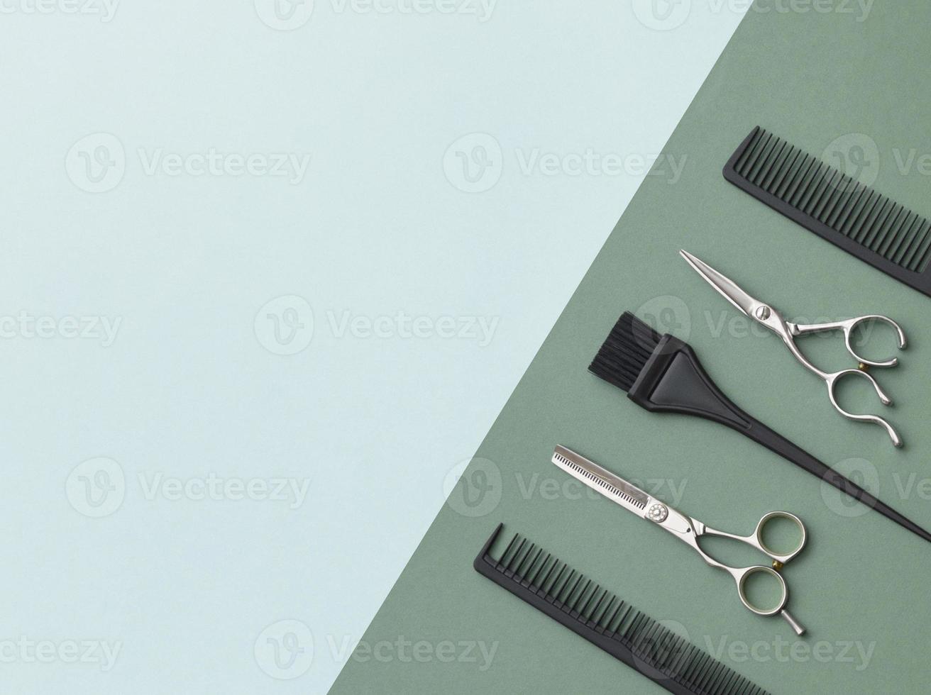 outils de coiffure sur fond vert et feuille bleue avec espace pour le texte. accessoires de salon de coiffure noir et acier, peigne et ciseaux. photo