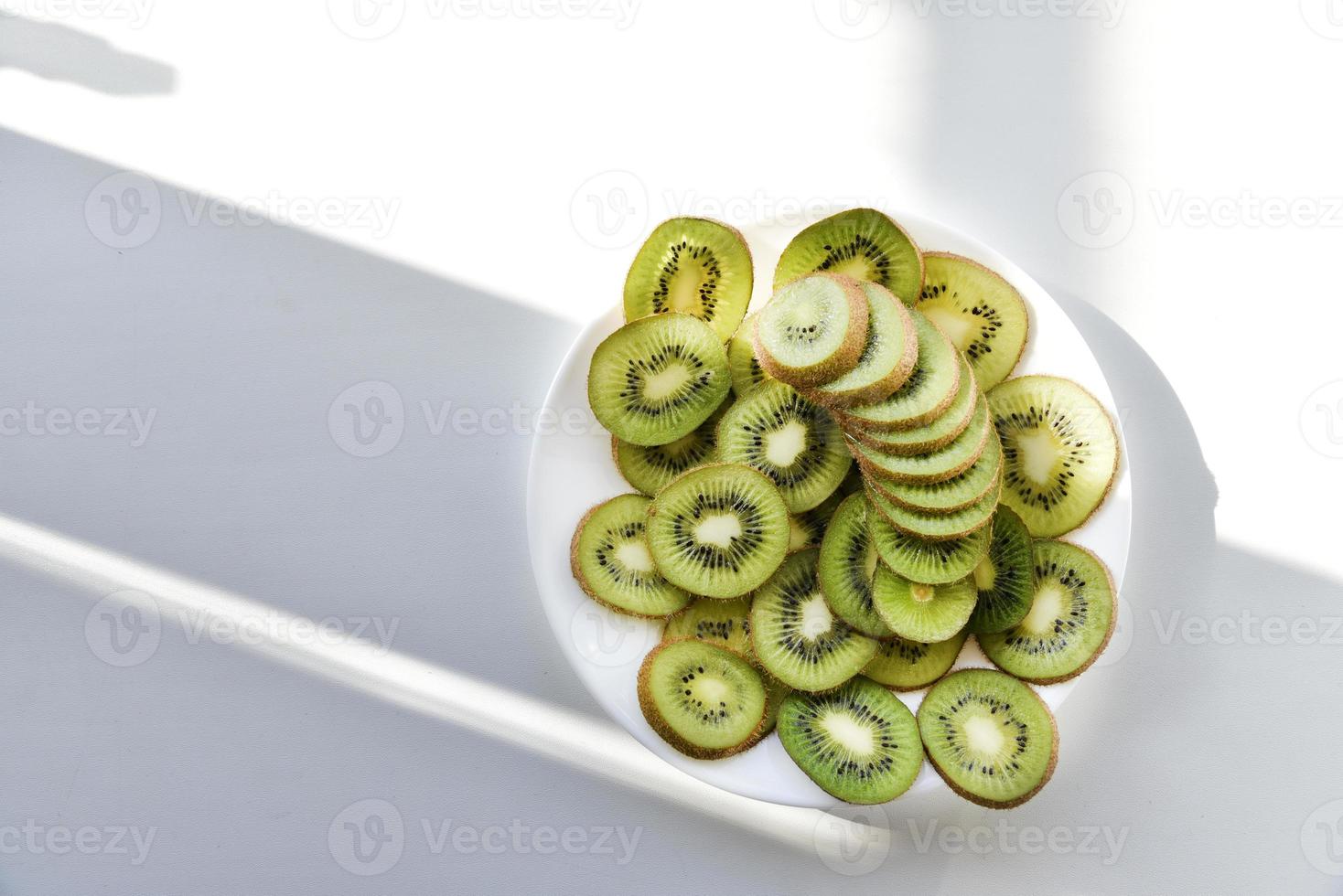 kiwis tranchés sur une assiette blanche photo