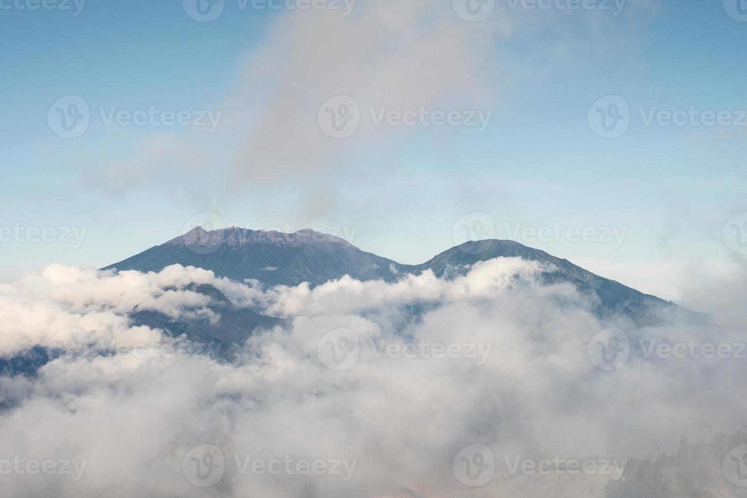 mont volcan actif dans le brouillard et le ciel bleu le matin à kawah ijen photo