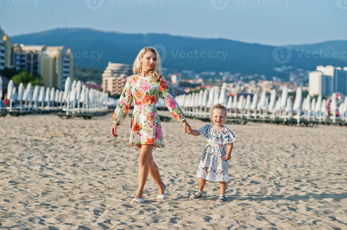 mère et belle fille s'amusant sur la plage. portrait d'une femme heureuse avec une jolie petite fille en vacances. photo