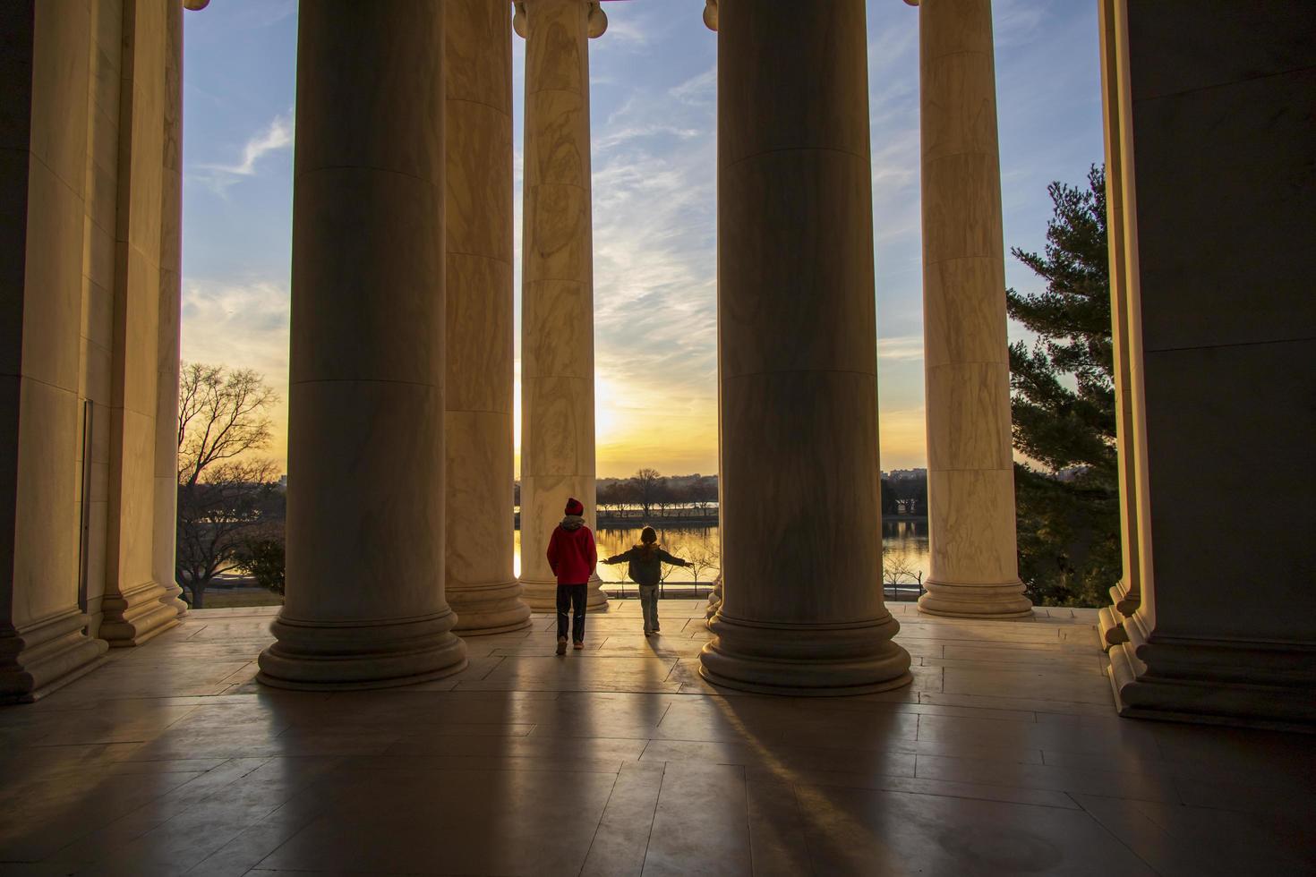 enfants jouant près de piliers géants à un monument quand le soleil se couche photo