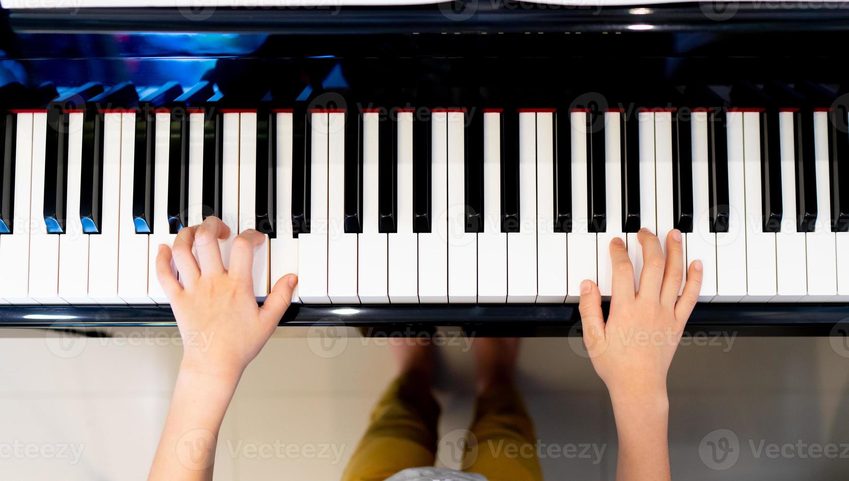 jouer du piano vue de dessus, garçon jouant à la main ou pratiquer la vue de dessus du piano photo