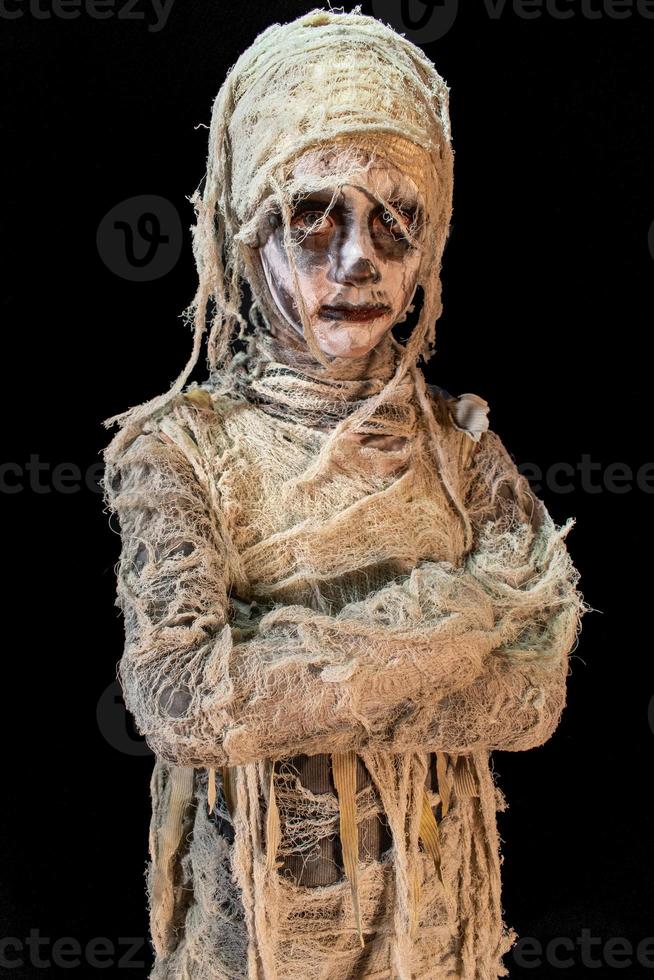 portrait tourné en studio d'un jeune garçon en costume habillé en halloween, cosplay de momie effrayante pose sur fond noir isolé photo