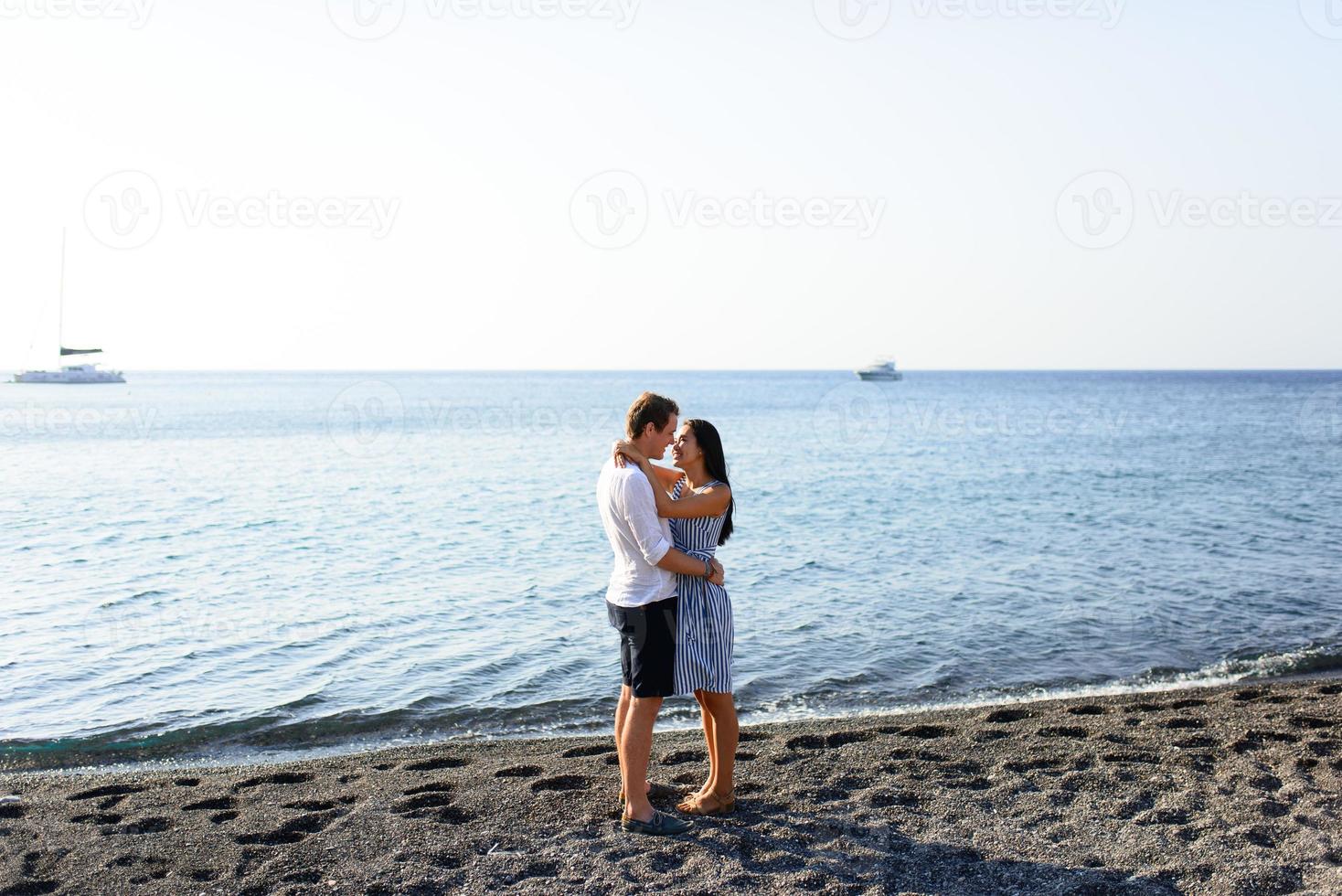 jeune beau couple s'embrassant sur fond de mer. photo