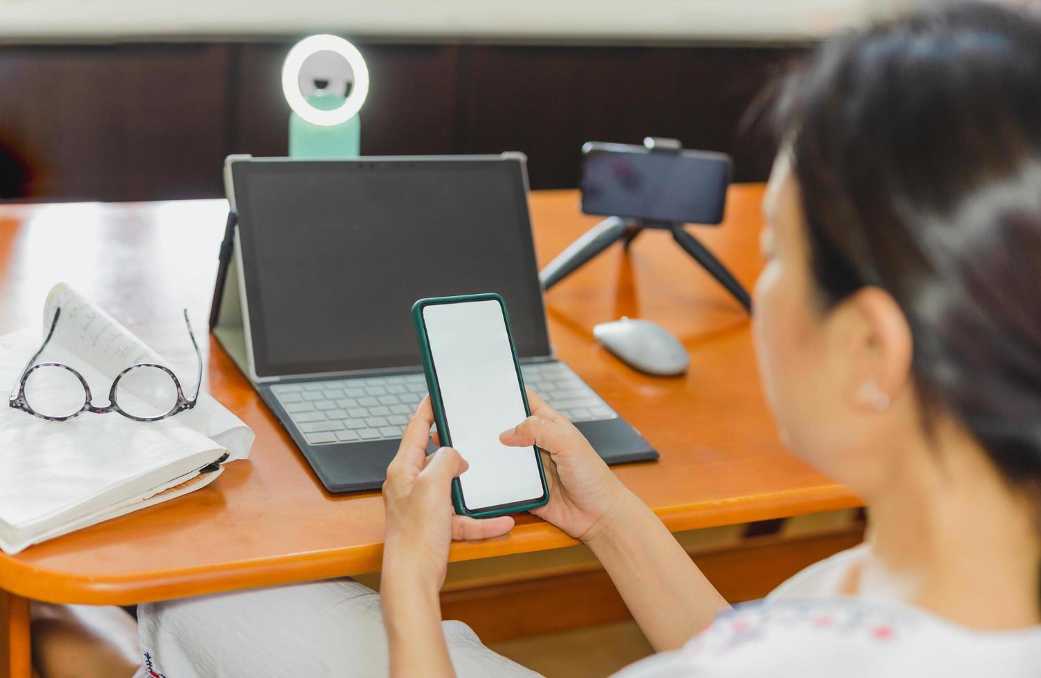 femme vérifiant le téléphone portable avant de travailler en ligne en direct. photo