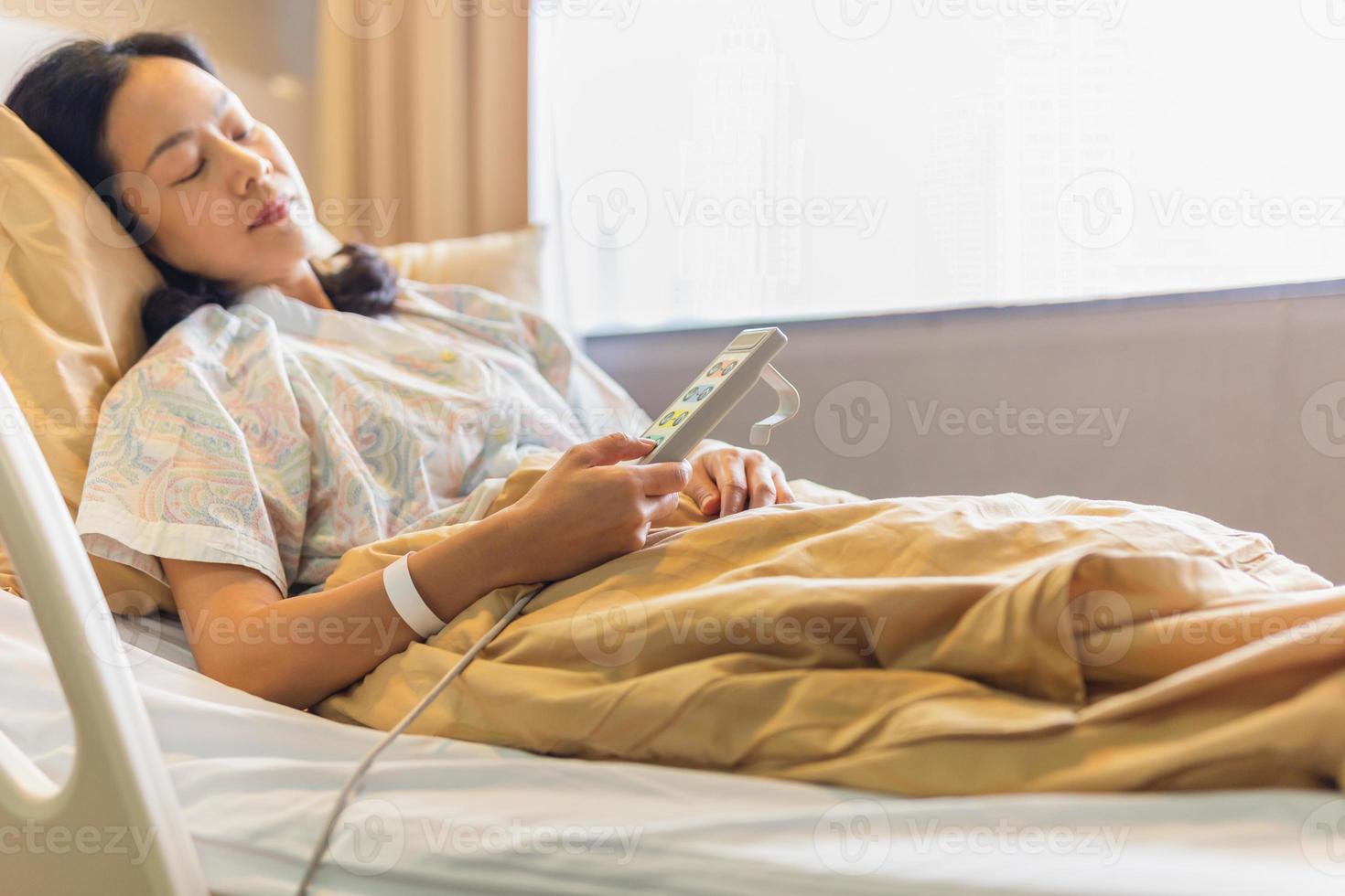 main de patiente à l'aide de la télécommande pour régler le lit de niveau à l'hôpital. photo