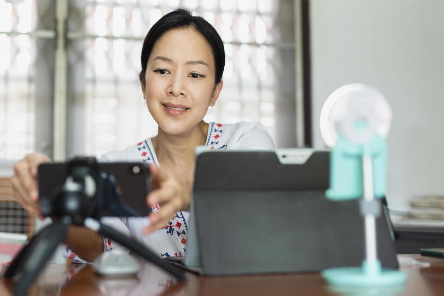 femme travaillant en ligne préparant la diffusion en direct au bureau à domicile. photo