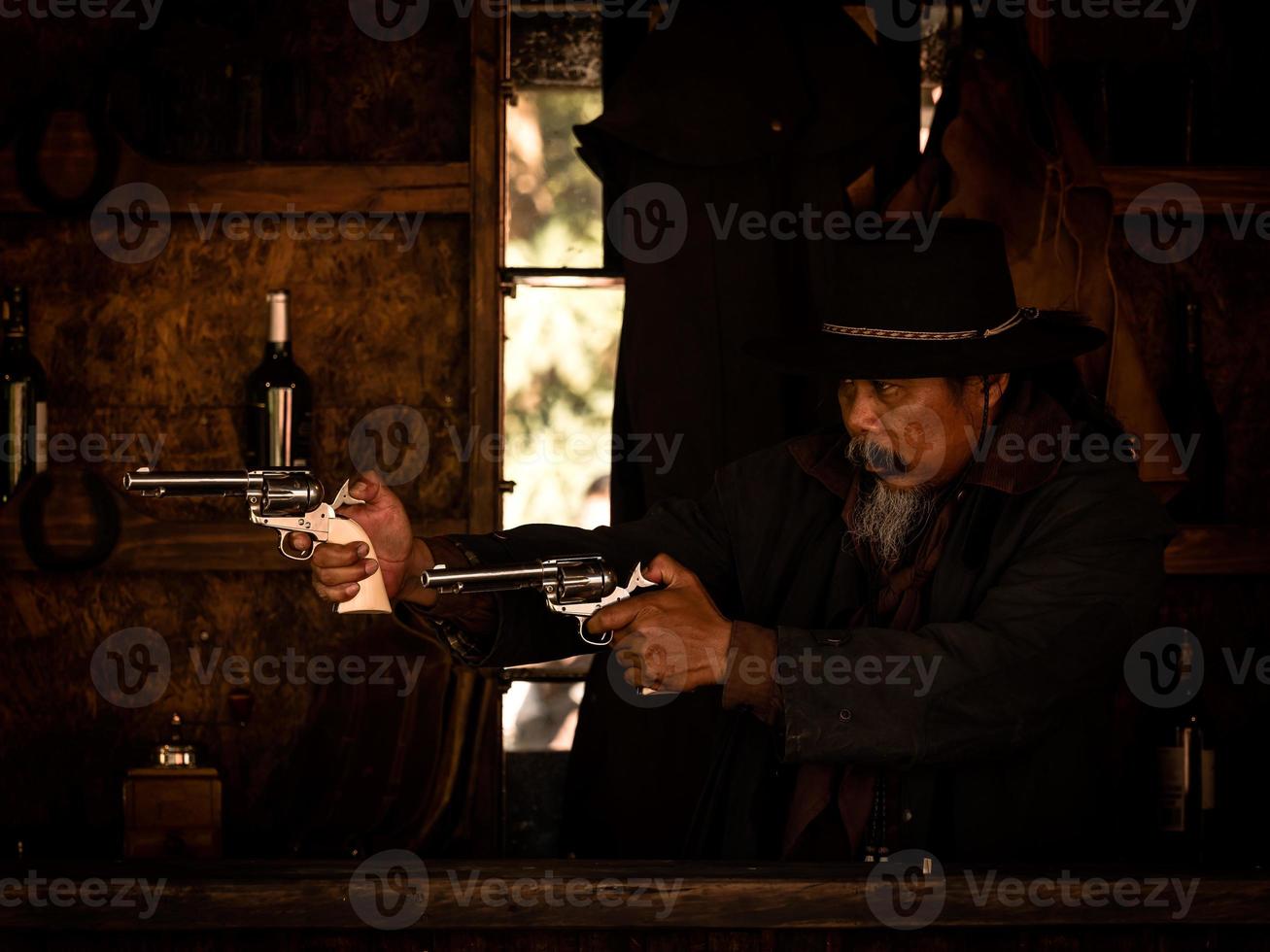 les cow-boys de l'ouest utilisent des fusils pour se battre pour se protéger dans la taverne, sur la terre que la loi n'a pas encore atteinte photo