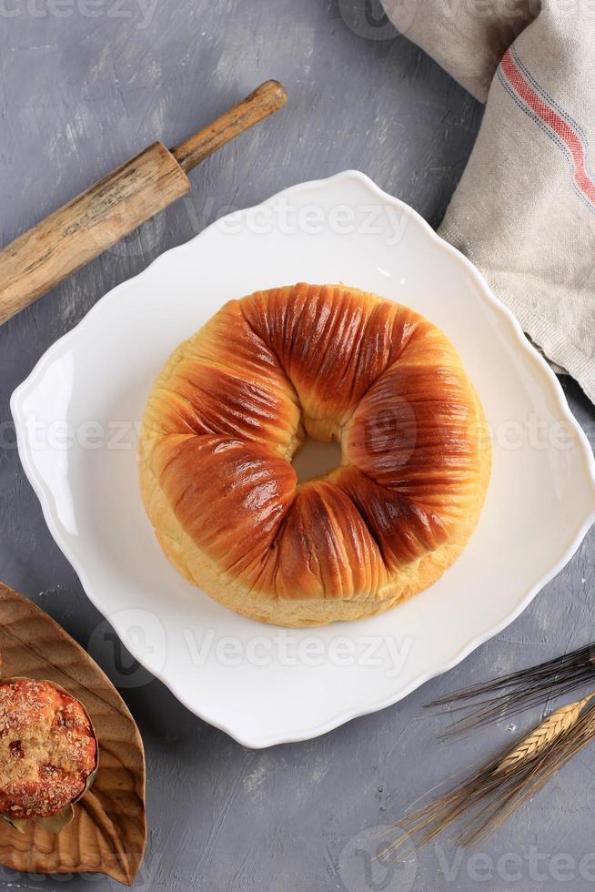 le pain de laine est une pâte à pain sucrée en forme de boule de fil de laine. fourré de chocolat et de fromage râpé. servi dans une assiette blanche photo