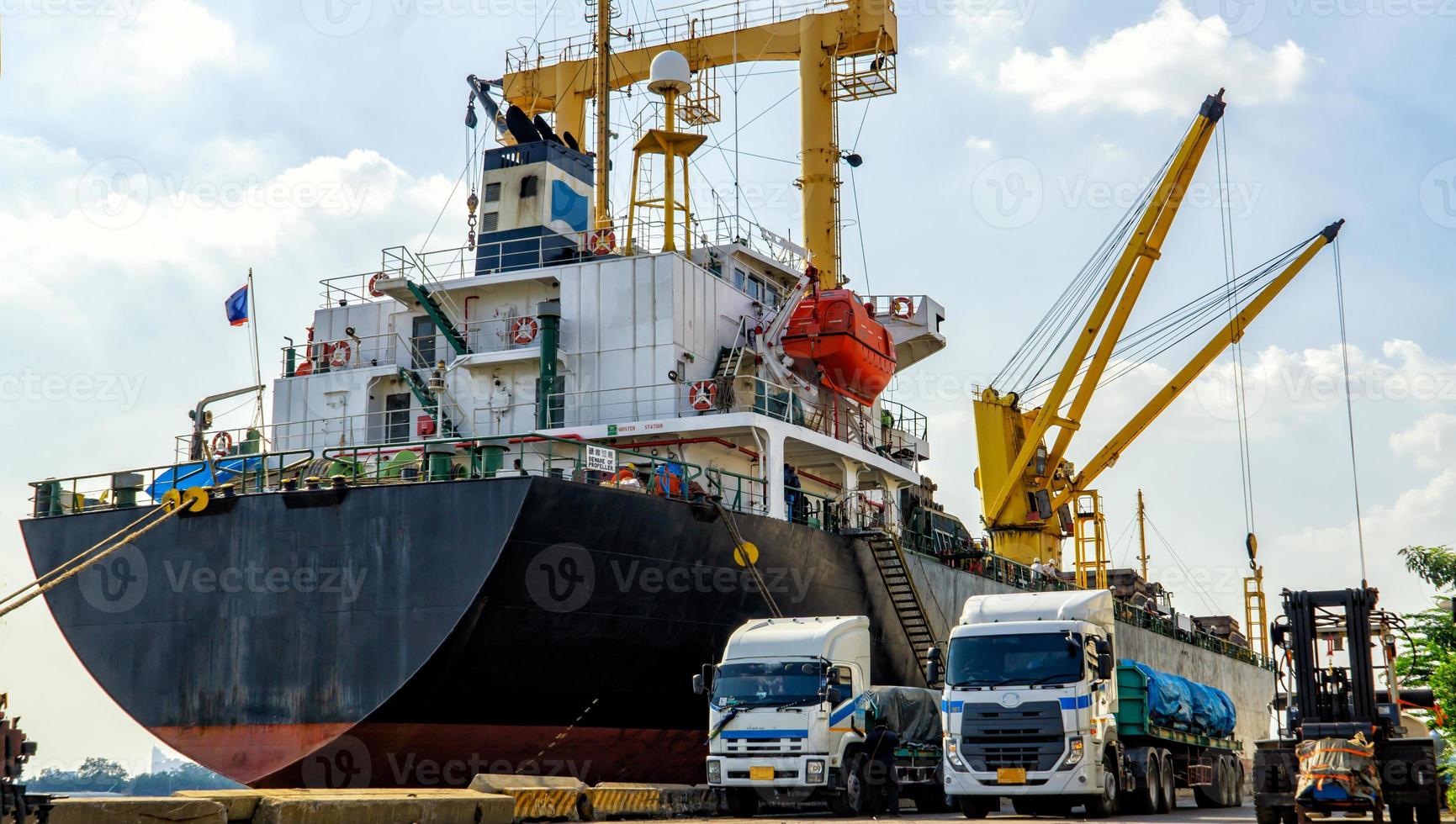 chargement de conteneurs dans un navire de fret avec grue industrielle. porte-conteneurs dans une entreprise de logistique commerciale d'importation et d'exportation. concept d'industrie et de transport. photo