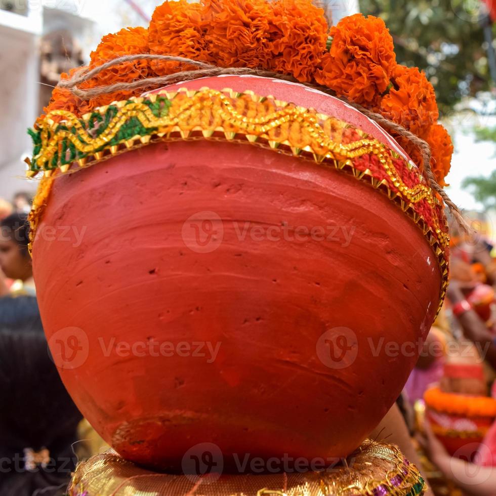 les femmes avec kalash sur la tête pendant le temple de jagannath mangal kalash yatra, les dévots hindous indiens portent des pots en terre contenant de l'eau sacrée avec une noix de coco sur le dessus photo