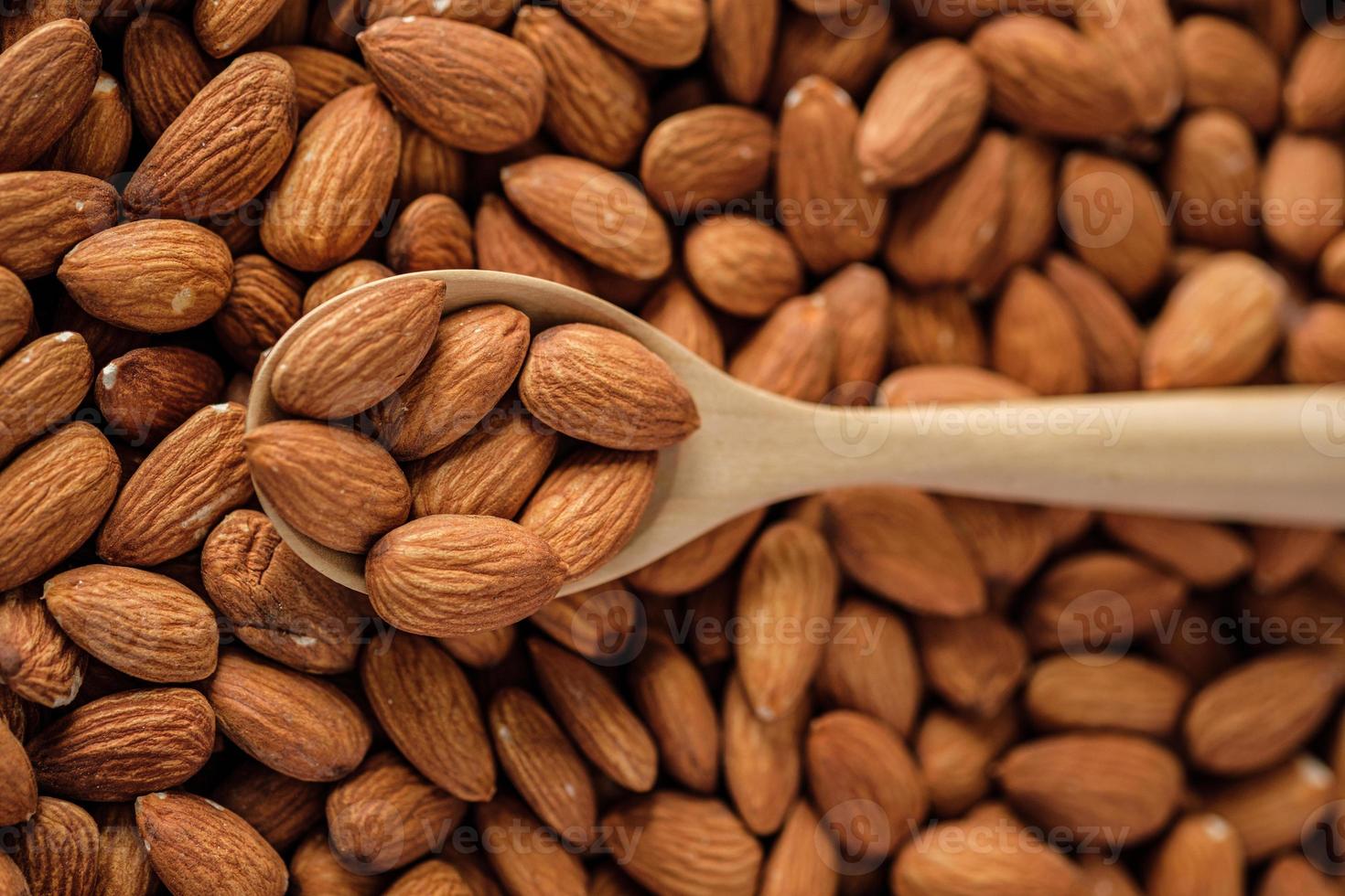 amandes dans un bol en bois sur une table en bois.matière première diététique photo