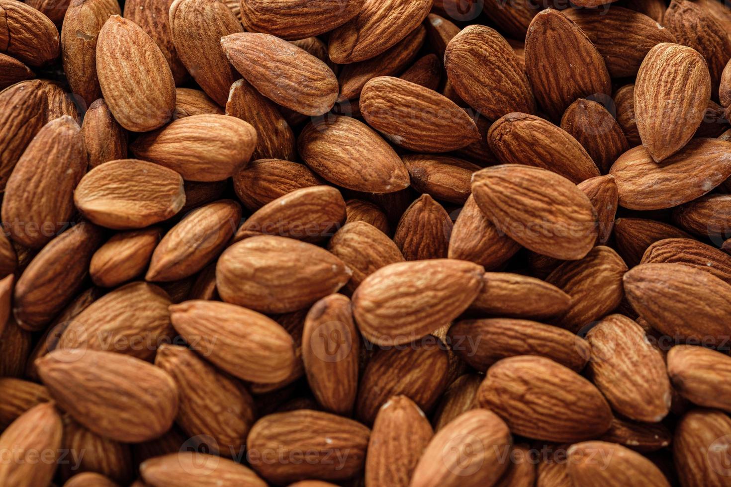 amandes dans un bol en bois sur une table en bois.matière première diététique photo