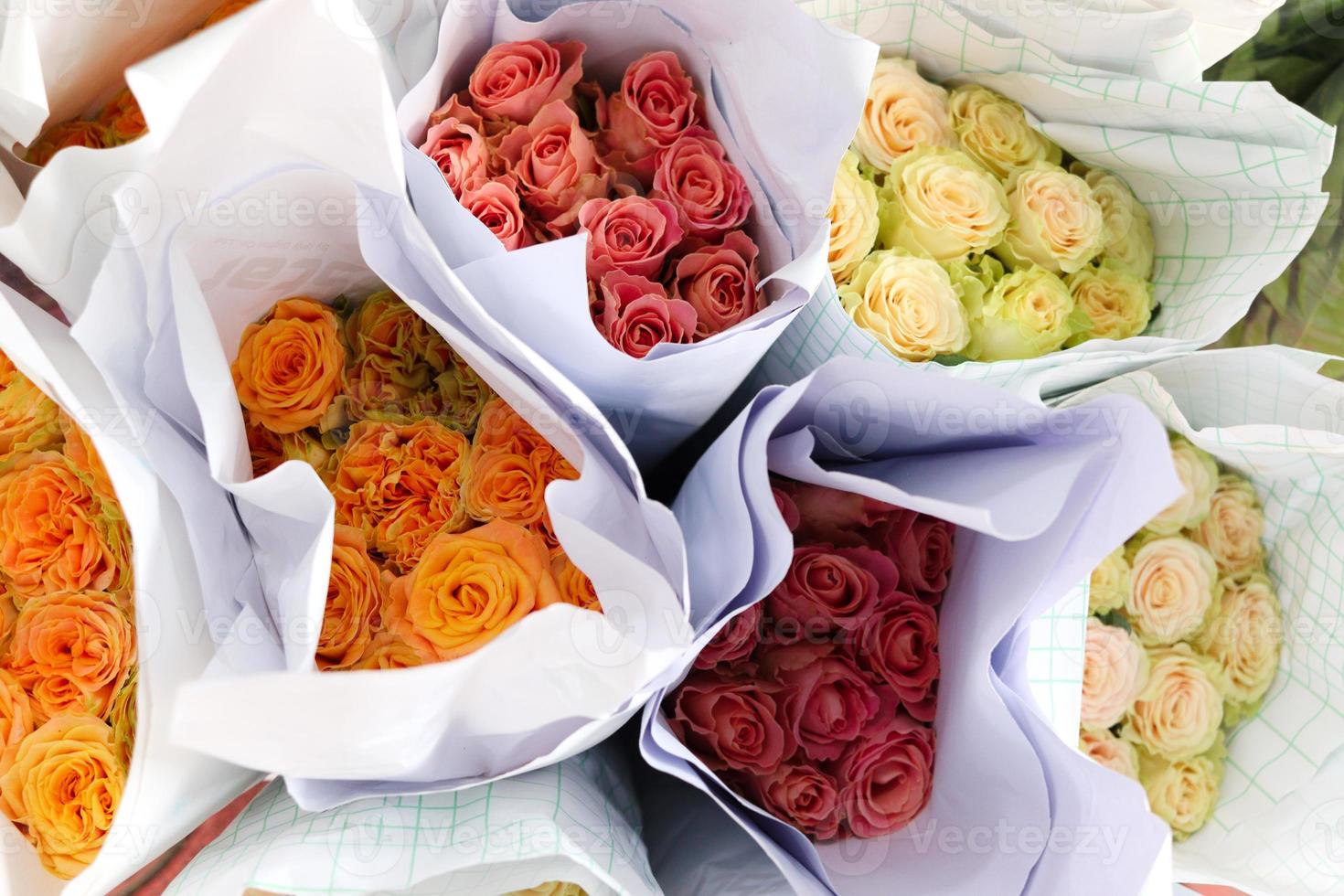 belle rose colorée enveloppée dans du papier en vente au marché aux fleurs, cadeau présent le jour de la saint-valentin. photo