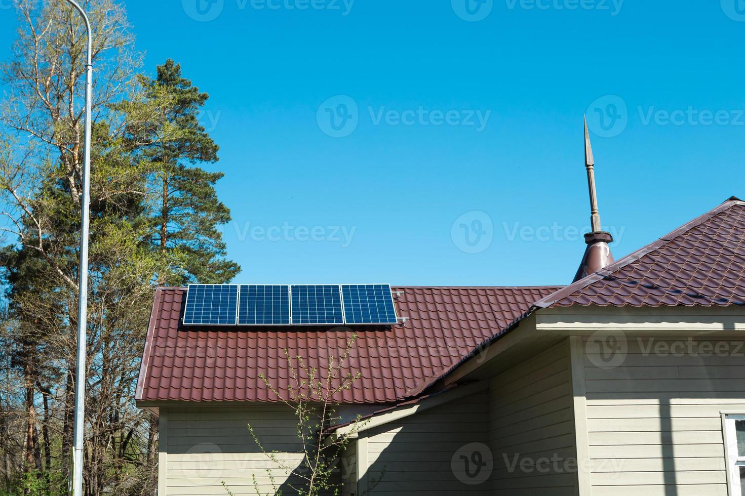 panneaux solaires sur le toit d'une maison privée d'un étage à la campagne. utilisation respectueuse de l'environnement de l'énergie solaire, une source alternative. prendre soin de la nature, préserver les ressources photo