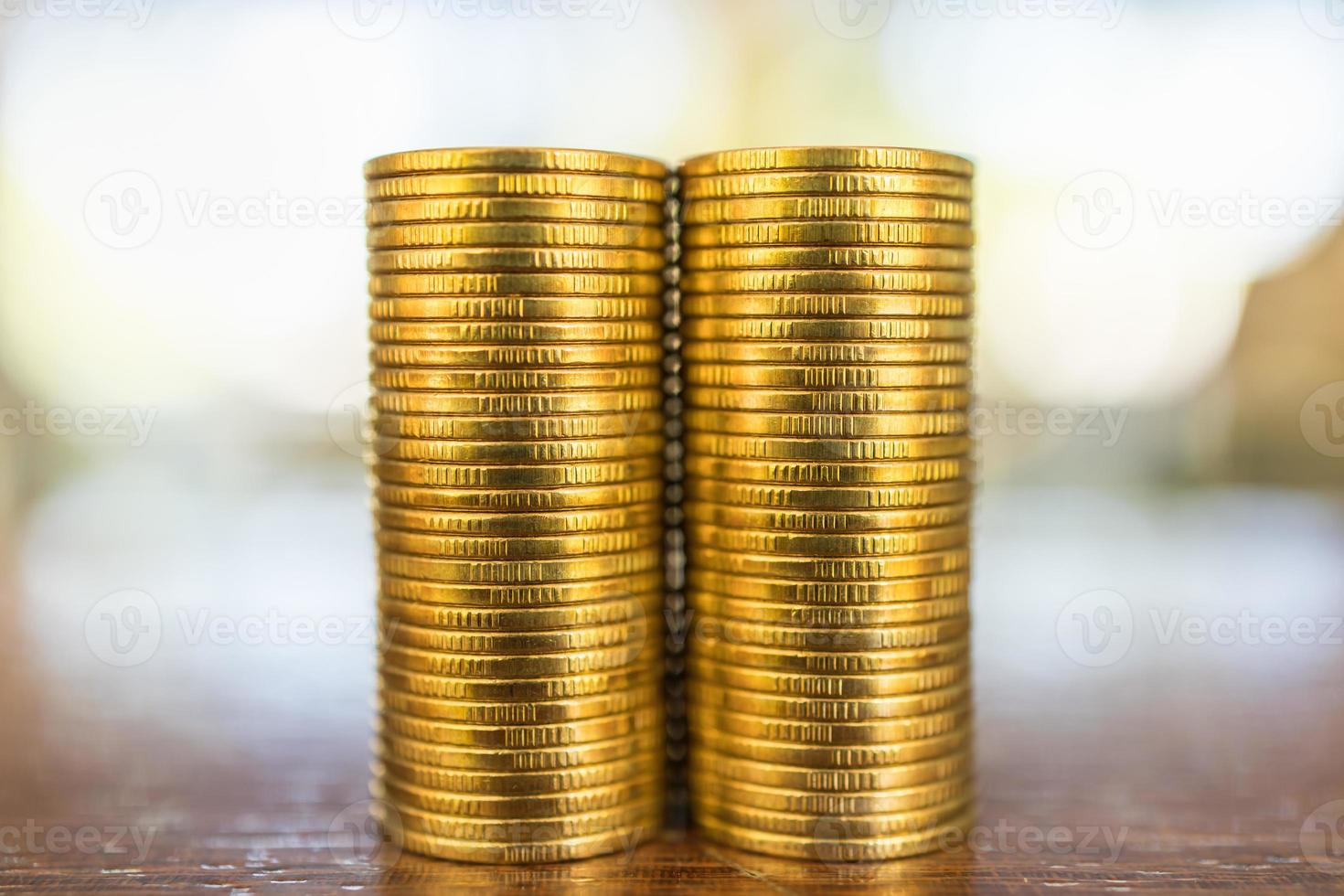 concept d'entreprise, d'argent, de finance, de sécurité et d'épargne. gros plan de deux piles de pièces d'or sur une table en bois sous la lumière du soleil. photo