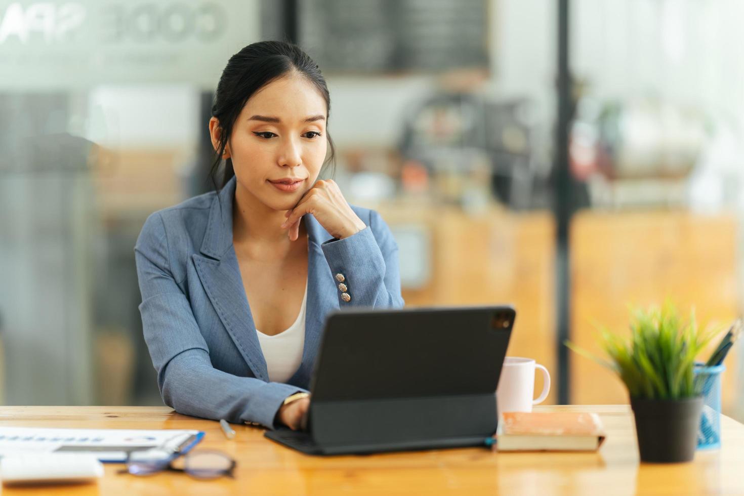 portrait d'une jeune femme asiatique travaillant sur un ordinateur portable au bureau, concept financier et d'investissement d'entreprise. photo