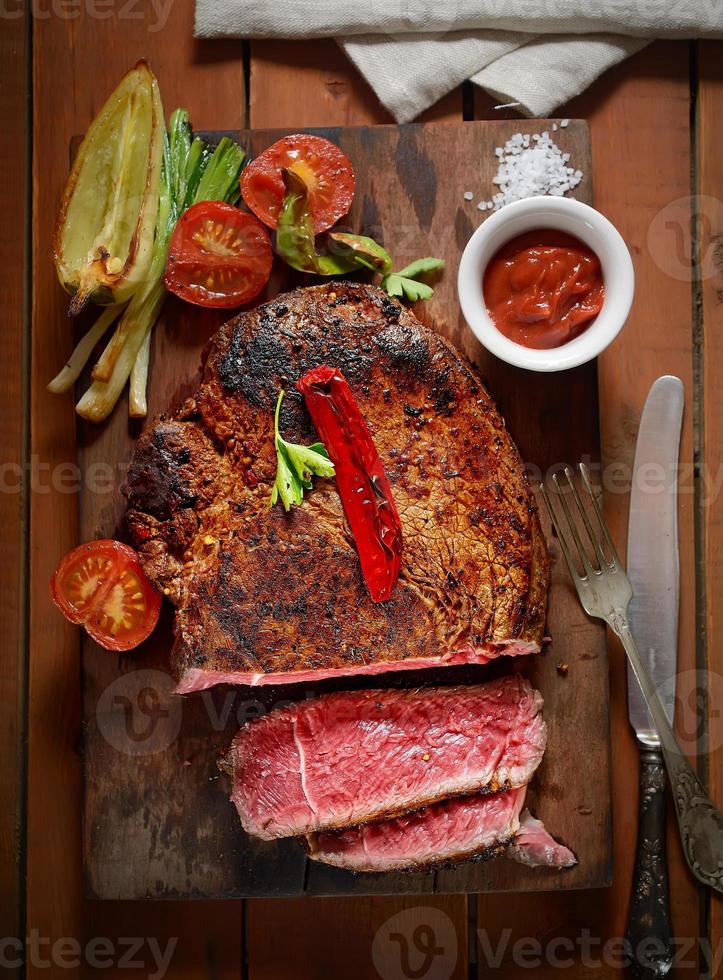 steak sur le fond en bois avec des légumes grillés photo