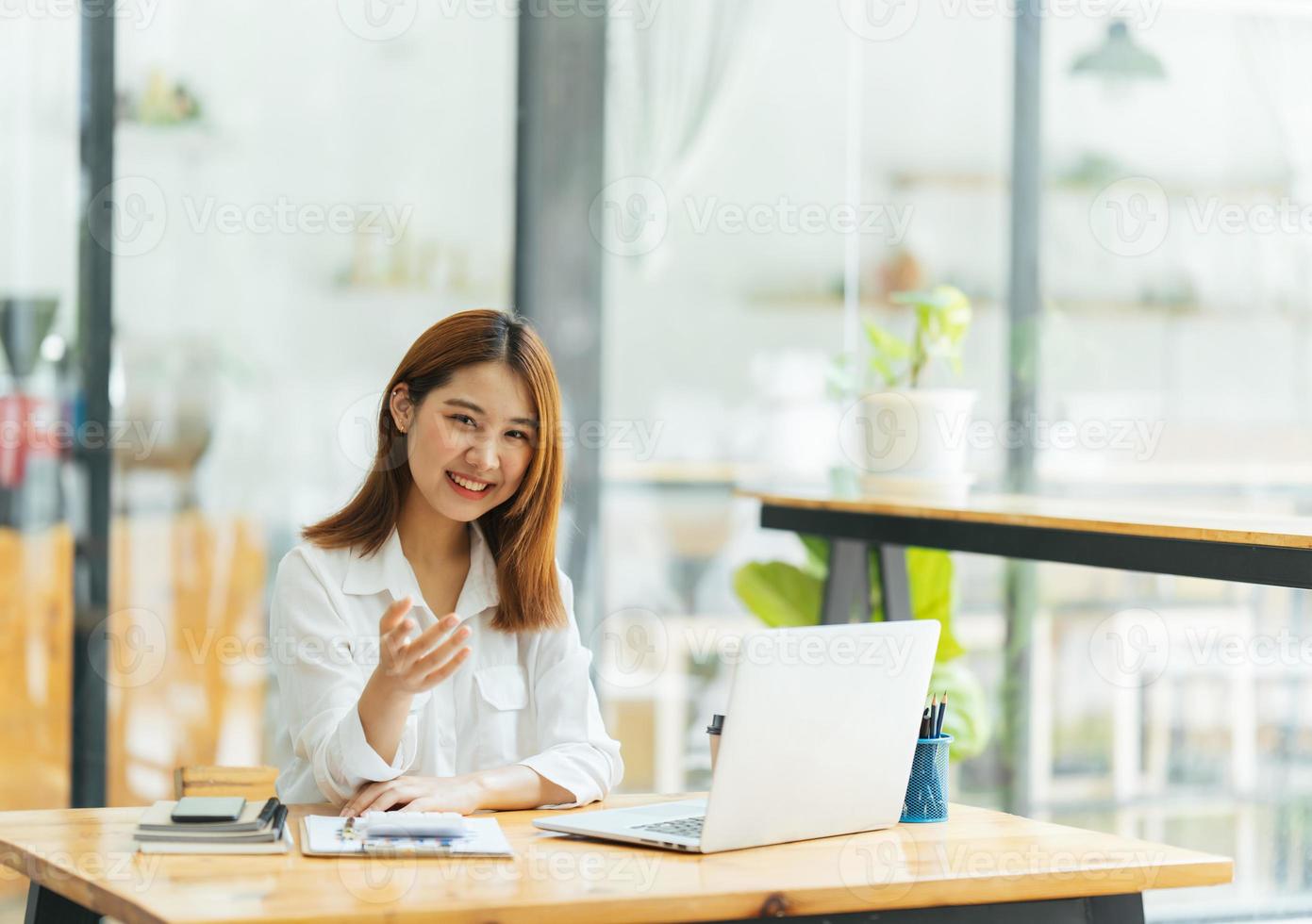 réunion en ligne. heureuse jeune femme utilisant un ordinateur portable pour une conférence virtuelle, ayant un appel vidéo à la maison. joyeuse femme asiatique communiquant avec des collègues, des amis à distance. photo
