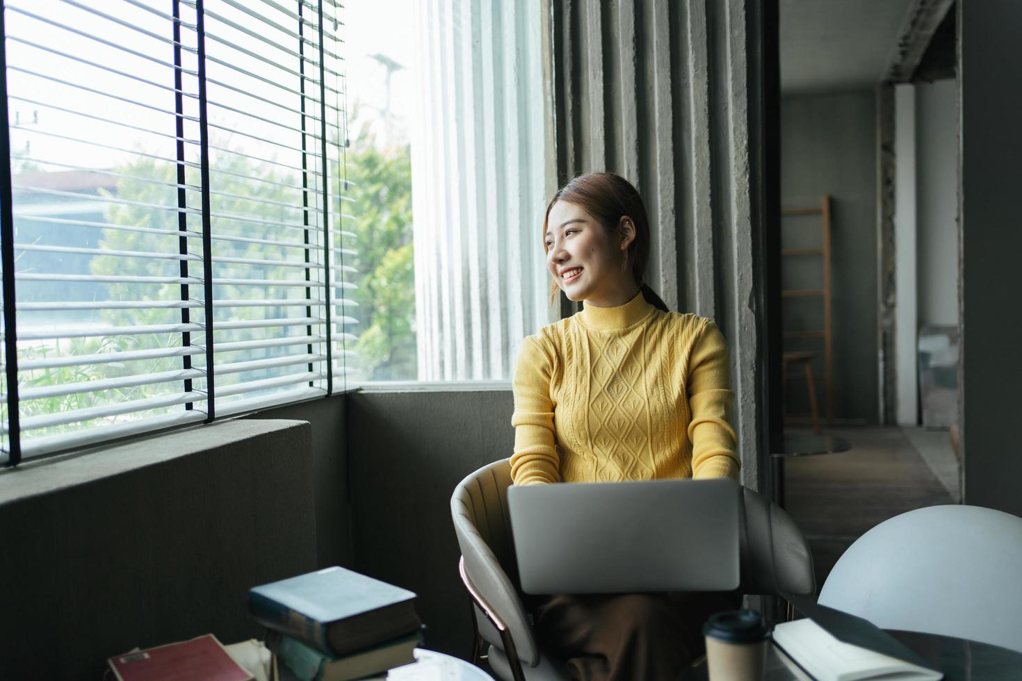 portrait d'une belle femme asiatique assise à l'intérieur au café-restaurant pendant l'été, à l'aide d'un ordinateur portable et d'un smartphone à technologie sans fil intelligente, pause-café relaxante au café-restaurant. photo