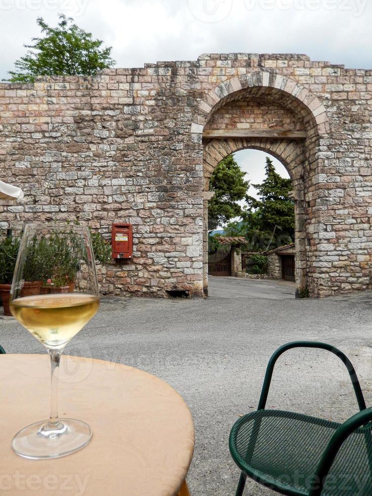 tir vertical d'un verre de boisson sur une table avec un vieux bâtiment en arrière-plan photo