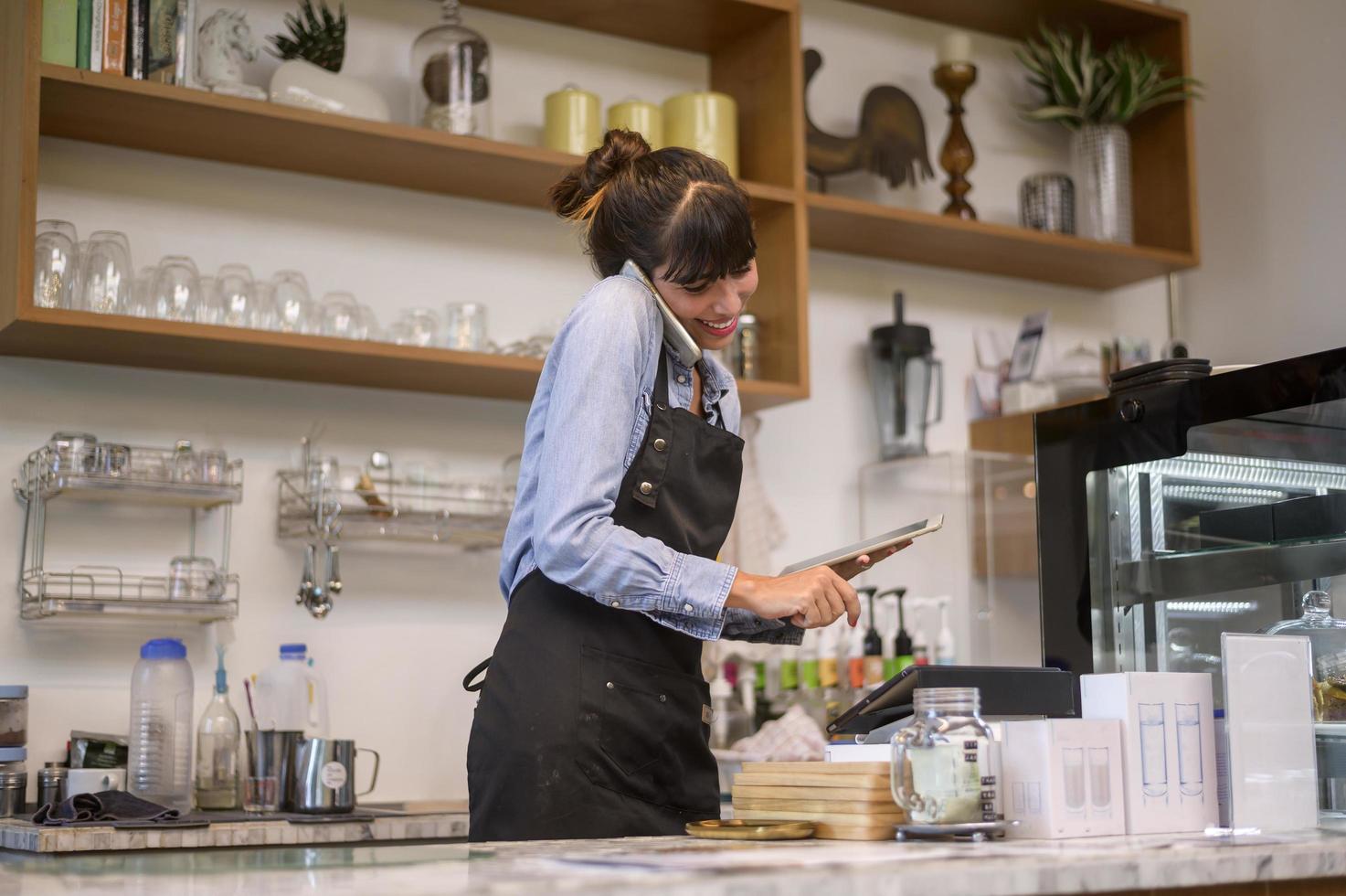 jeune femme barista soucieuse du service travaillant dans un café photo