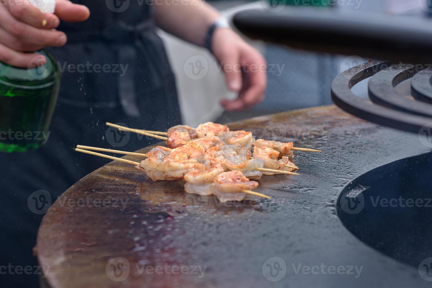 cuisson des crevettes, brochettes de crevettes sur le gril au festival de l'alimentation de rue - gros plan photo