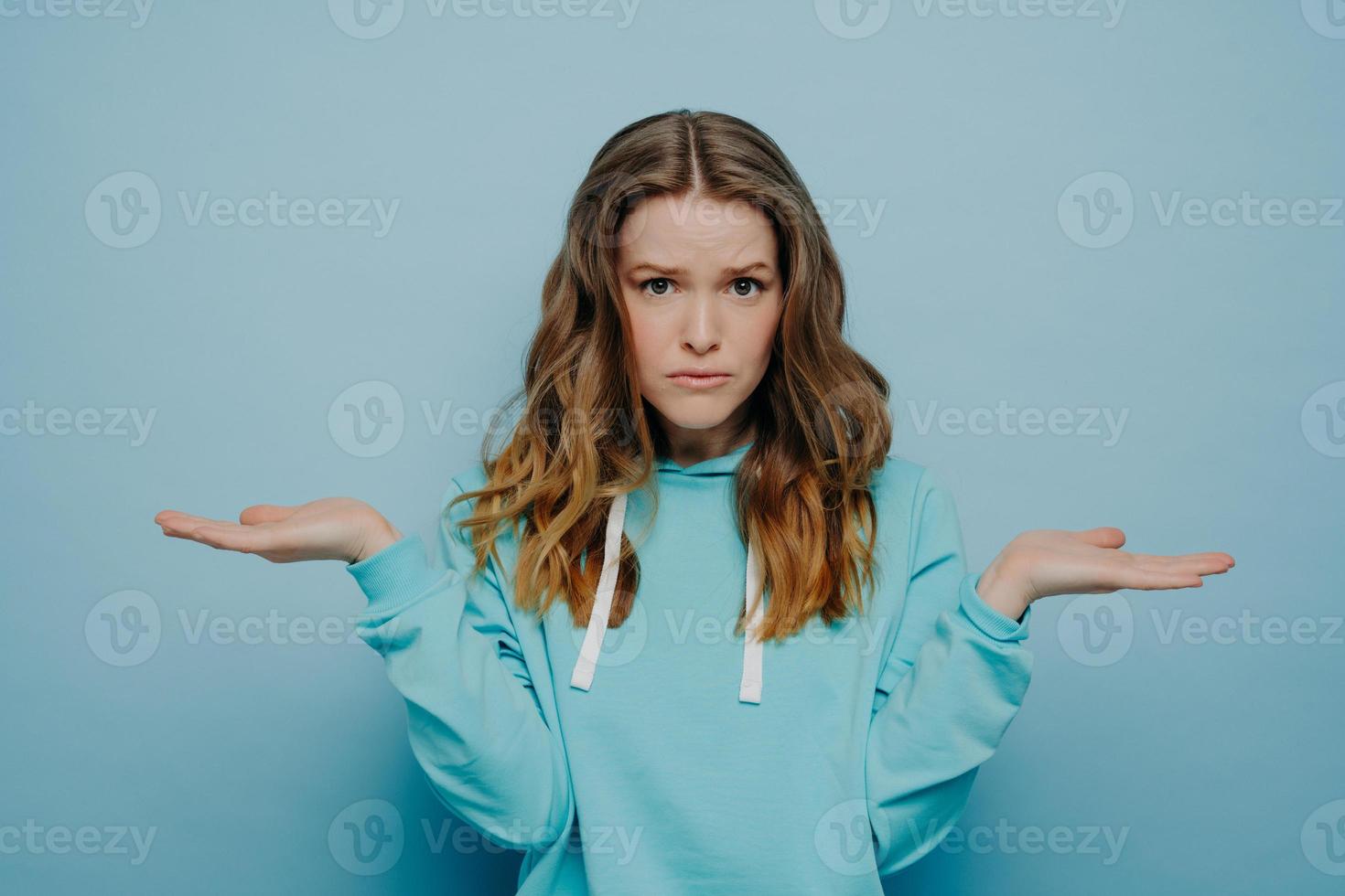 jeune femme en tenue décontractée avec une expression faciale de doute et d'hésitation photo