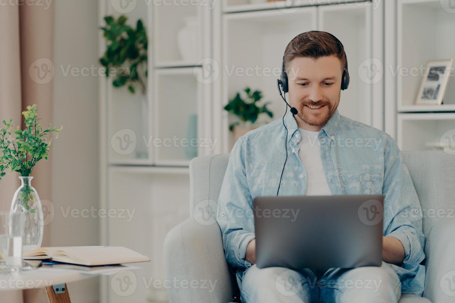 barbu souriant discutant en ligne avec un ami à la maison photo