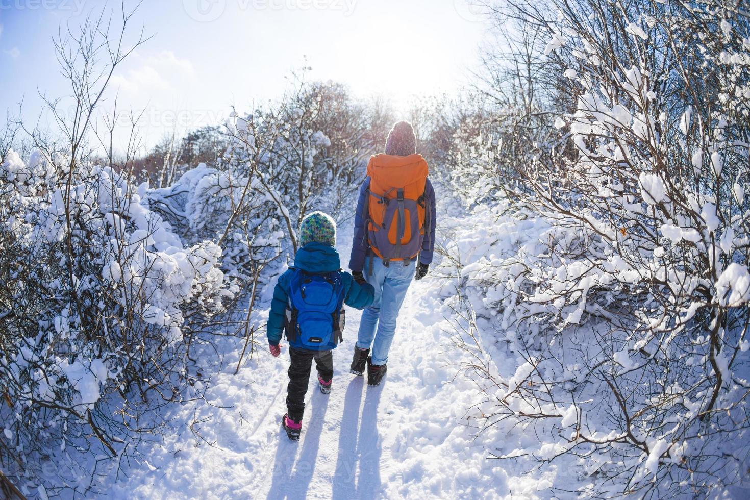 femme avec un enfant lors d'une randonnée hivernale dans les montagnes. photo