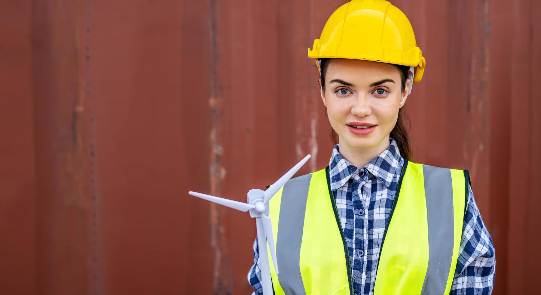 femme ingénieure créative ouvrière tenant un modèle d'éolienne, portrait d'une belle femme avec une miniature de moulin à vent dans les mains face à la caméra souriante photo