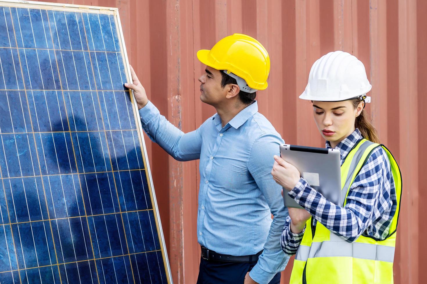 ingénieurs énergétiques masculins avec son équipe de collègues femmes discutant d'un nouveau projet sur le point d'investir dans l'installation de cellules solaires à l'extérieur d'un bâtiment ou d'une usine industrielle photo