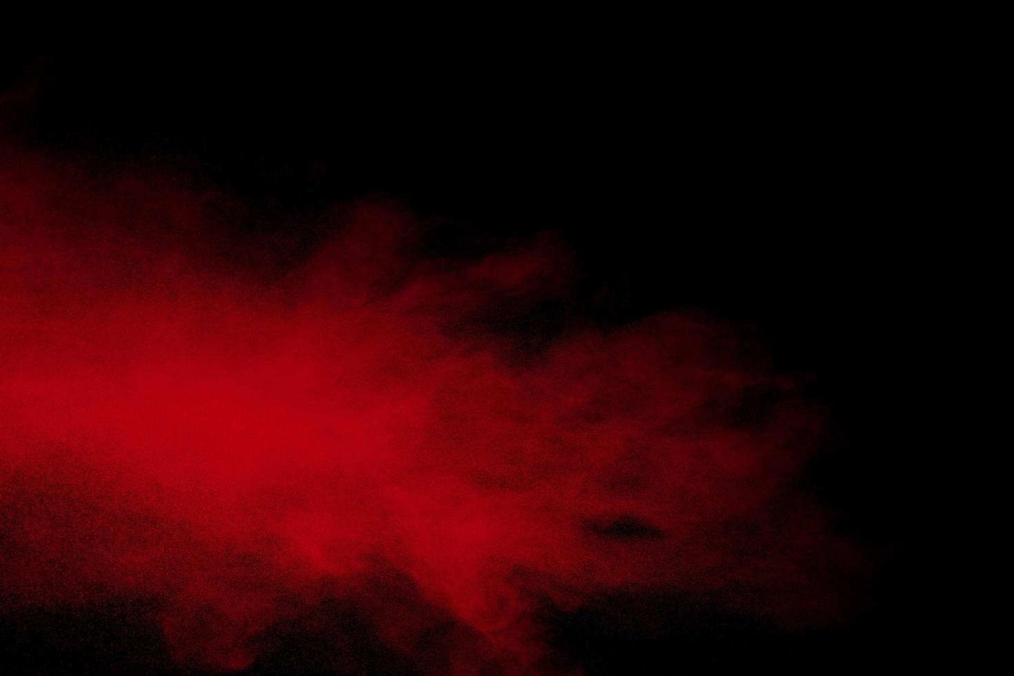 explosion de poudre rouge sur fond noir. photo