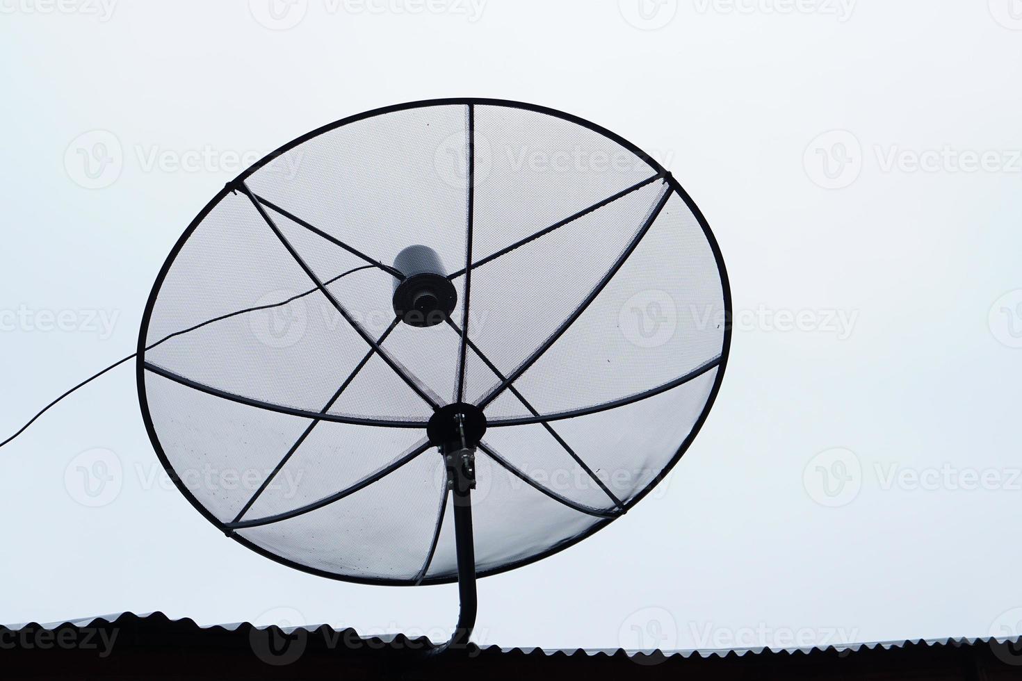 silhouette d'une antenne parabolique sur le toit d'une maison photo