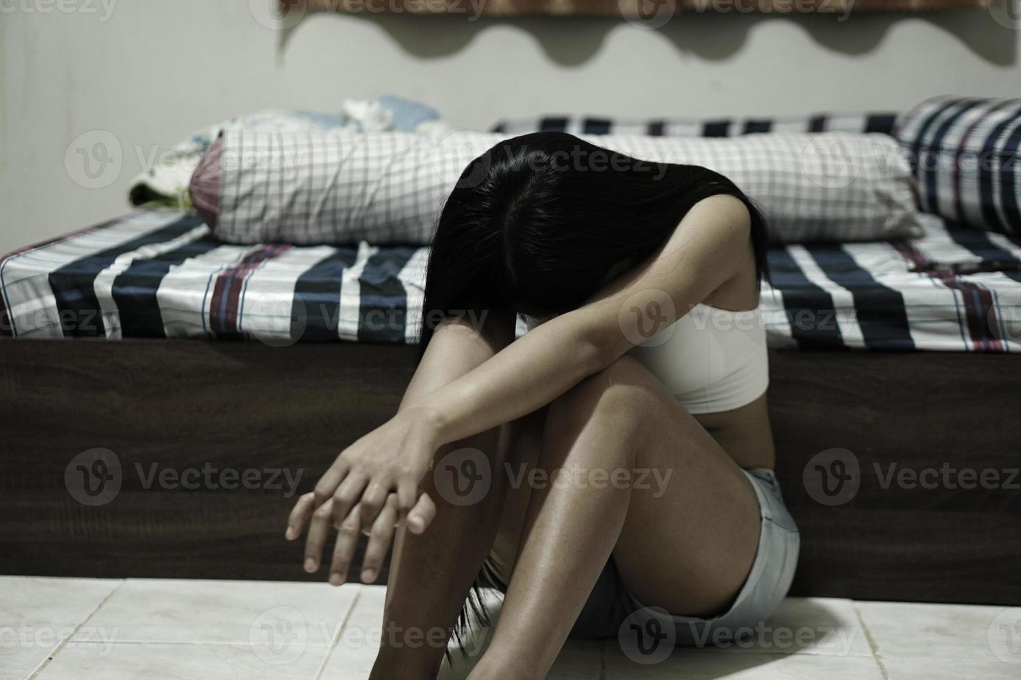 femme asiatique assise dans la chambre à coucher en train de pleurer photo
