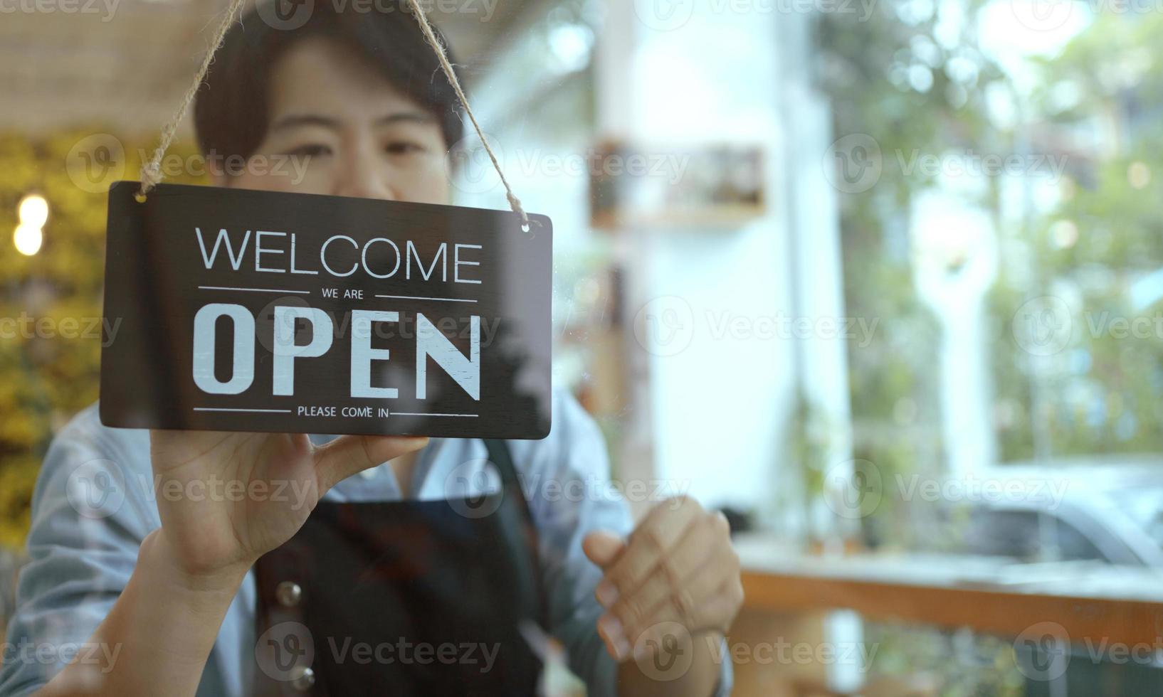 propriétaire d'entreprise femme asiatique tournant désolé signe fermé sur le magasin de porte en verre fronton. photo